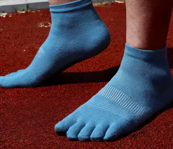 Blue Kintoe toe socks on a red running track.